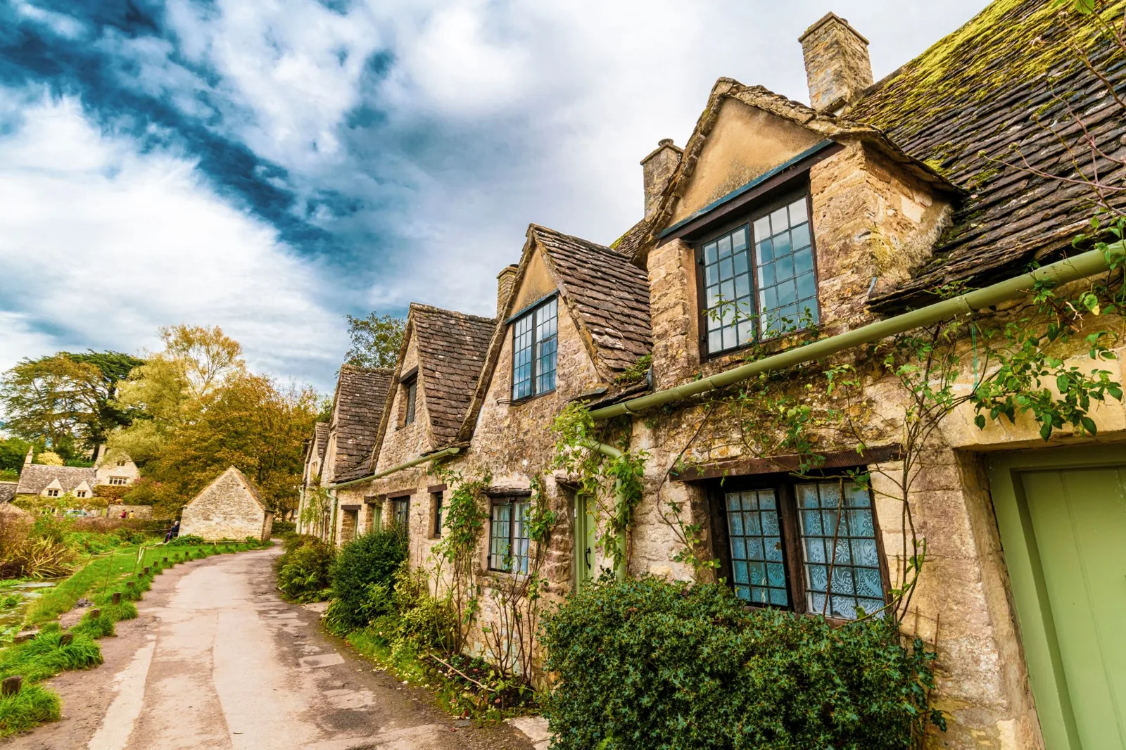 Charming old cottages line a picturesque street in Bibury, England.